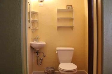 Bathroom with corner sink and shelving