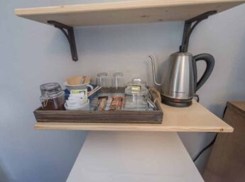 Coffee perculator and snacks on shelf
